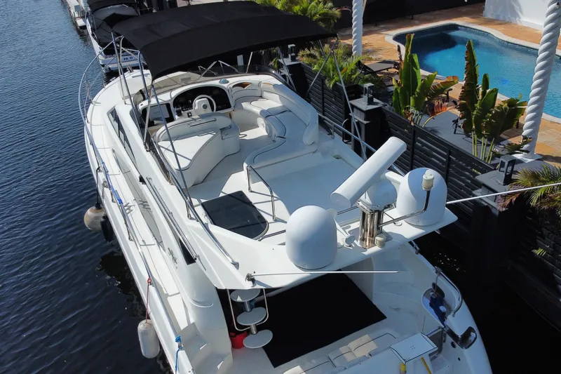 Slide: The Image of 1998 Azimut 52 yacht docked by a pool, featuring spacious deck and modern amenities. - 57