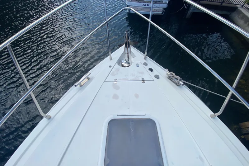 Slide: The Image of Bow view of a 1998 Azimut 52 yacht docked on calm water. - 9