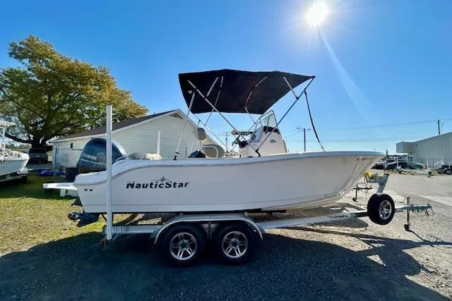 The Image of 2022 NauticStar 2102 Legacy boat on trailer under clear blue sky. - 1