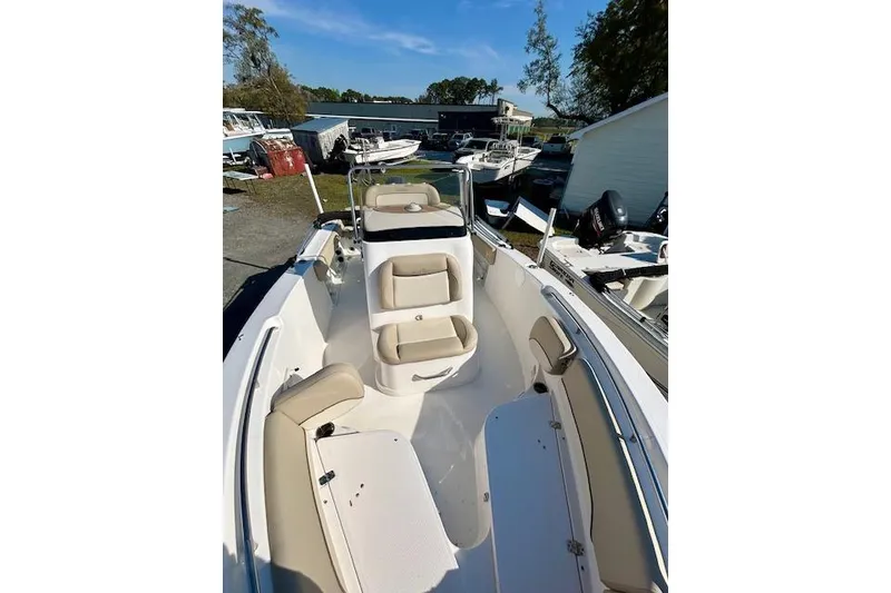 Slide: The Image of 2022 NauticStar 2102 Legacy boat with beige seating, docked outdoors. - 7