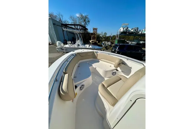 Slide: The Image of 2022 NauticStar 2102 Legacy boat with beige seating, docked outdoors. - 8