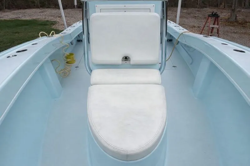 Slide: The Image of 2019 Stoner 23 CC boat interior with white cushioned seating and light blue deck. - 10