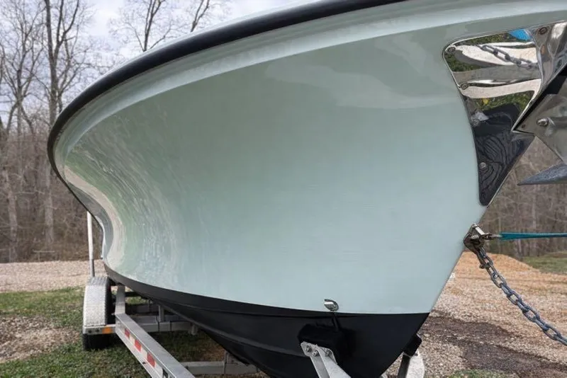 Slide: The Image of 2019 Stoner 23 CC boat on trailer, showcasing sleek hull design in wooded area. - 5