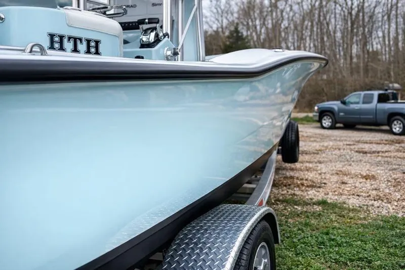 Slide: The Image of 2019 Stoner 23 CC boat on trailer, parked outdoors near a pickup truck. - 6