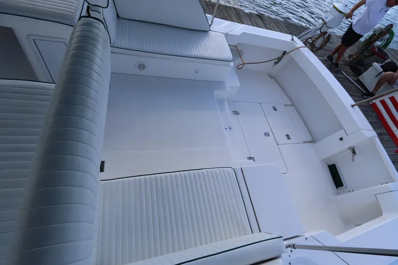 Slide: The Image of 2002 Mainship Pilot 34 boat deck with white cushioned seating and storage compartments. - 14