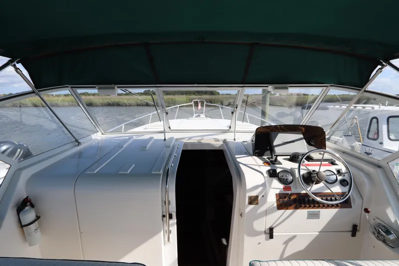 Slide: The Image of 2002 Mainship Pilot 34 cockpit with steering wheel and navigation instruments. - 17