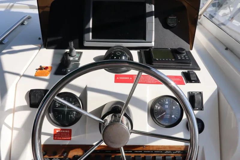 Slide: The Image of Helm of 2002 Mainship Pilot 34 with steering wheel and navigation instruments. - 26