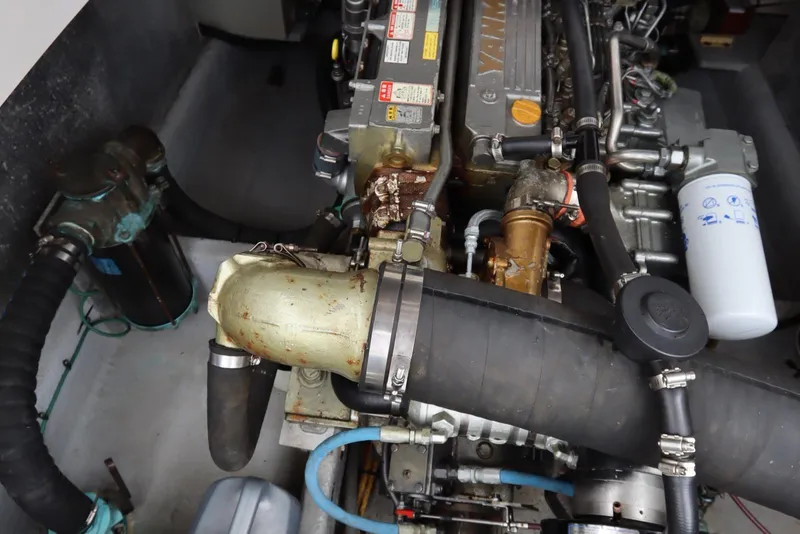 Slide: The Image of Engine compartment of a 2001 Mainship Pilot 34 boat, showcasing mechanical components and hoses. - 37