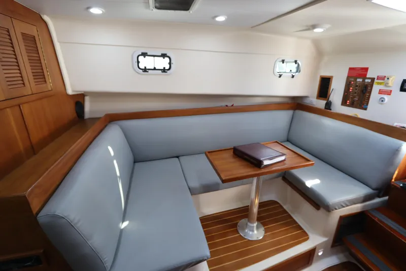 Slide: The Image of 2002 Mainship Pilot 34 interior with cozy seating and wooden table. - 44