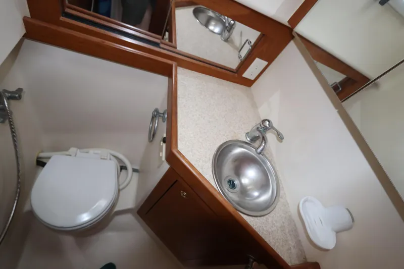 Slide: The Image of 2002 Mainship Pilot 34 bathroom with sink, toilet, and mirror. - 45