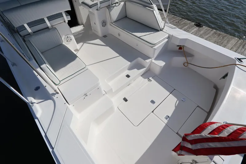 Slide: The Image of 2002 Mainship Pilot 34 boat deck with seating, storage, and American flag. - 6