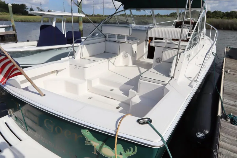 Slide: The Image of 2002 Mainship Pilot 34 boat docked, featuring spacious seating and American flag. - 8