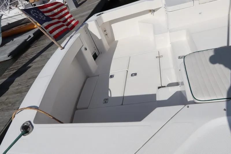 Slide: The Image of 2002 Mainship Pilot 34 boat deck with American flag, featuring spacious seating and storage. - 9
