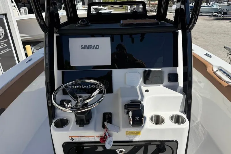 Slide: The Image of 2026 Sea Pro 242 Center Console helm with Simrad display and steering wheel. - 11