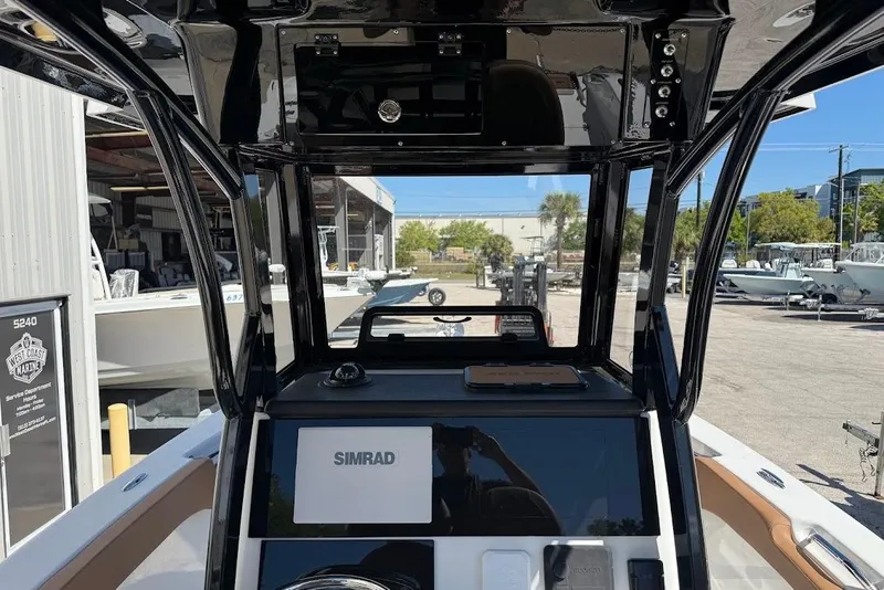 Slide: The Image of 2026 Sea Pro 242 Center Console boat interior with Simrad display at marina. - 12