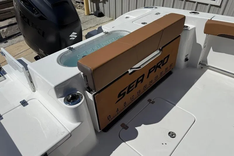 Slide: The Image of 2026 Sea Pro 242 Center Console boat interior with Suzuki engine and seating area. - 13