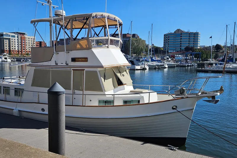 Slide: The Image of 1989 Grand Banks 36 Classic yacht docked in a marina with cityscape background. - 3