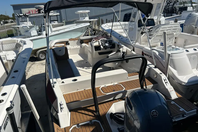 Slide: The Image of 2023 Starcraft SVX 211 IO boat with wood deck, parked among other boats. - 11