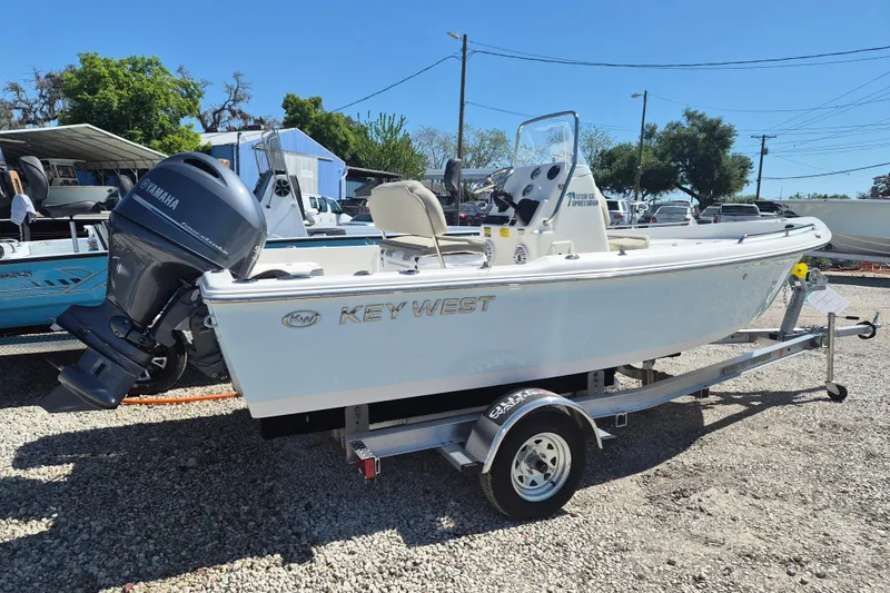 Slide: The Image of 2026 Key West 1720 Center Console boat with Yamaha 90 engine, parked outdoors. - 2