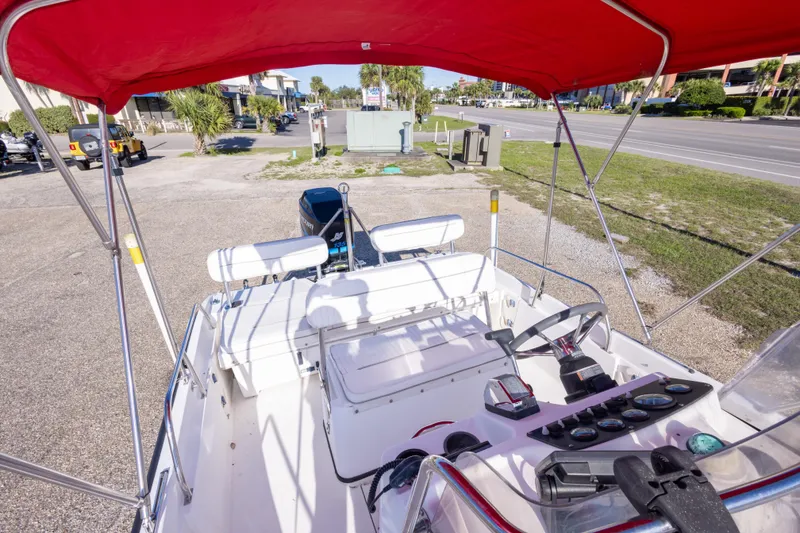 Slide: The Image of 2001 Boston Whaler 18 Dauntless boat with red canopy, parked on a sunny day. - 23