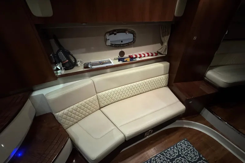 Slide: The Image of Interior of 2015 Chaparral 330 Signature yacht with cream seating and wooden accents. - 23