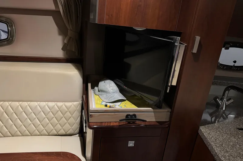Slide: The Image of Interior of 2015 Chaparral 330 Signature yacht with TV, cap, and seating area. - 29
