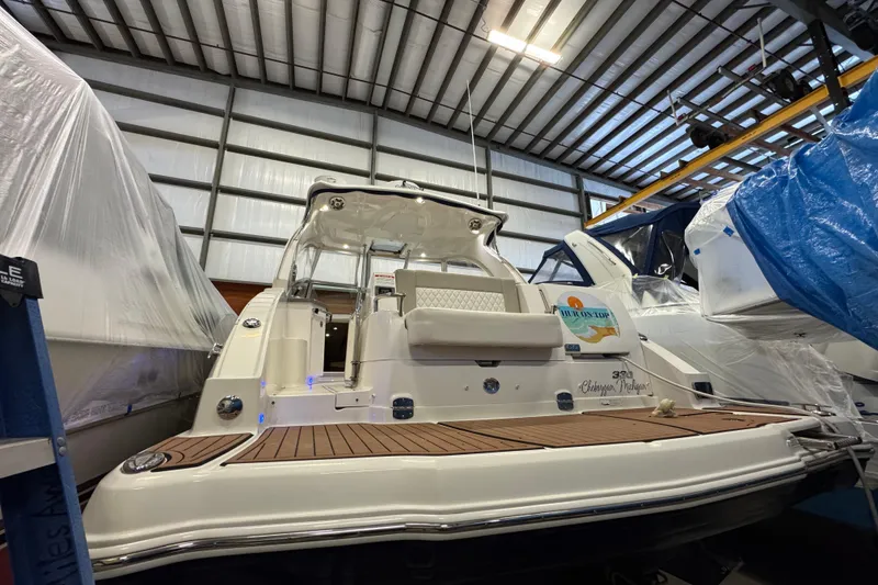 Slide: The Image of 2015 Chaparral 330 Signature boat in storage, rear view with wooden deck. - 3