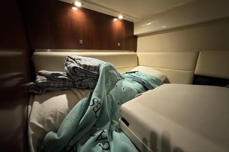 Slide: The Image of Cozy cabin interior of 2015 Chaparral 330 Signature with blankets and soft lighting. - 31
