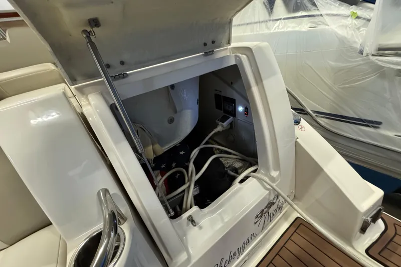 Slide: The Image of Open storage compartment on a 2015 Chaparral 330 Signature boat, showing cables and equipment. - 6