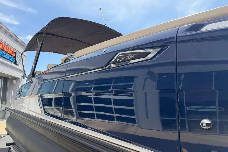 Slide: The Image of 2025 Balise HORIZON26C boat with sleek blue exterior at a dealership. - 12