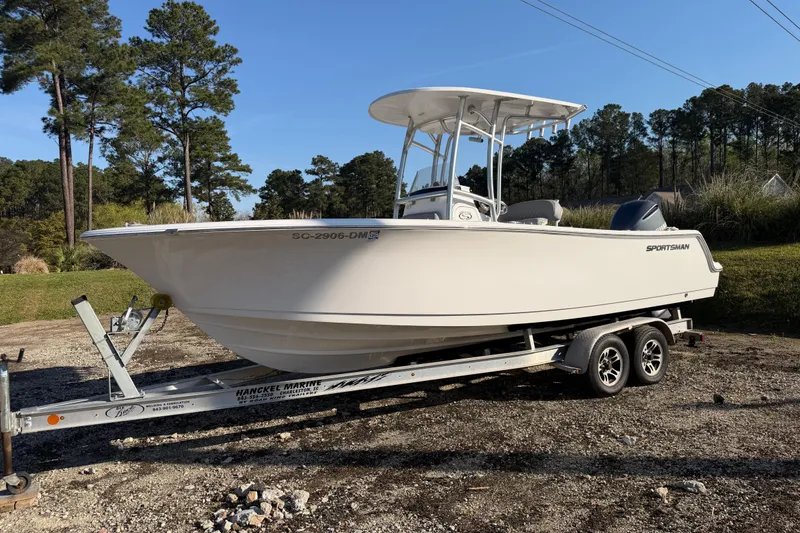 The Image of 2019 Sportsman Heritage 231 Center Console boat on trailer, parked outdoors. - 1