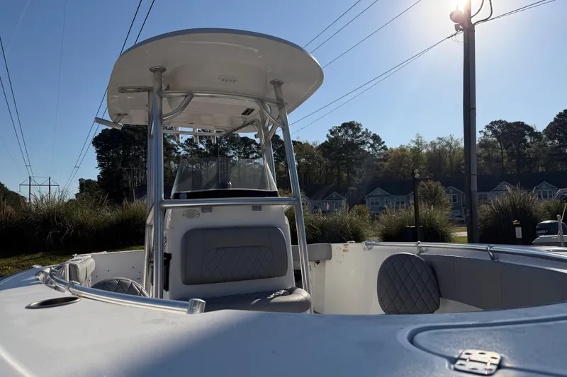 Slide: The Image of 2019 Sportsman Heritage 231 Center Console boat with seating, outdoors under clear sky. - 13