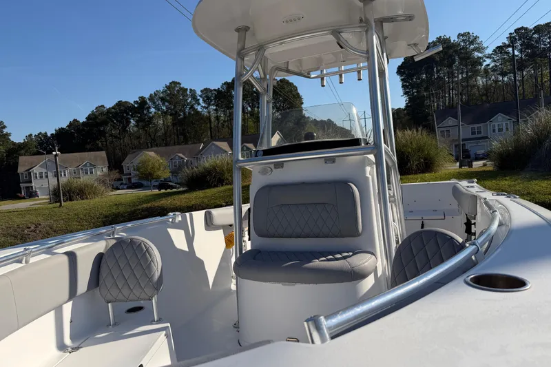 Slide: The Image of 2019 Sportsman Heritage 231 Center Console boat with cushioned seating, parked outdoors. - 14