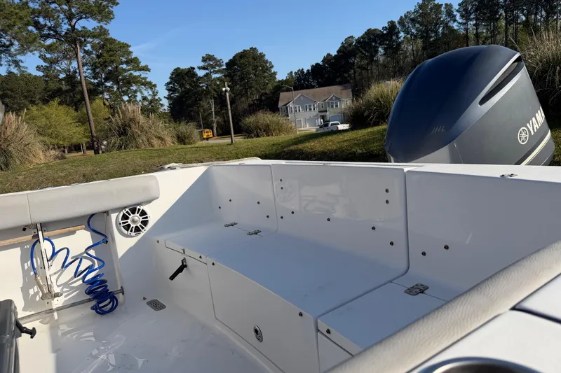 Slide: The Image of 2019 Sportsman Heritage 231 Center Console boat interior with Yamaha engine, parked near trees and houses. - 6