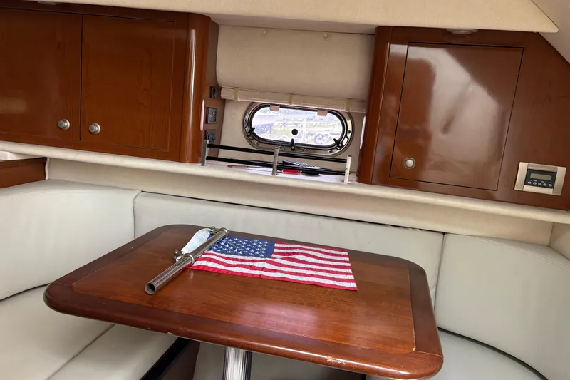 Slide: The Image of 2008 Searay 290 Amberjack cabin interior with wooden table and American flag decor. - 10