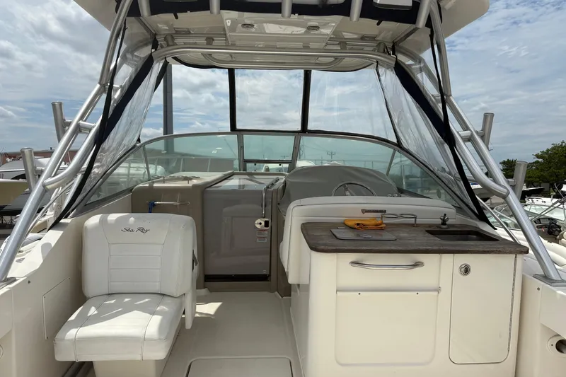 Slide: The Image of 2008 Searay 290 Amberjack boat interior with seating and kitchenette under a canopy. - 16