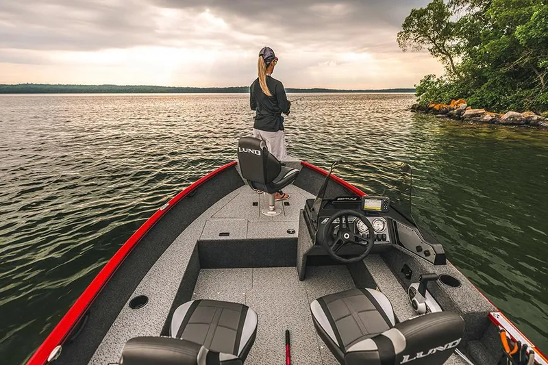 Slide: The Image of Manufacturer Provided Image: 2025 Lund 1650 Rebel XL SS boat on a serene lake, person fishing at sunset. - 6