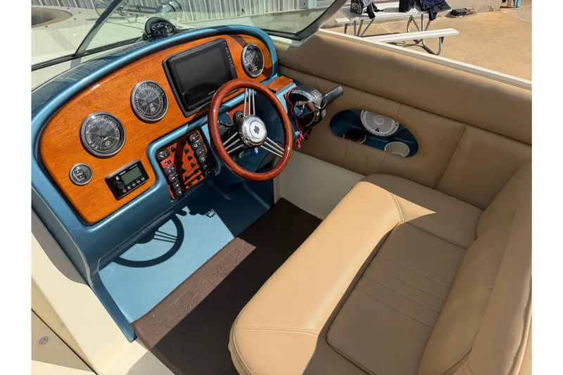 Slide: The Image of 2001 Chris-Craft Launch 28 boat dashboard with wood accents and beige seating. - 14