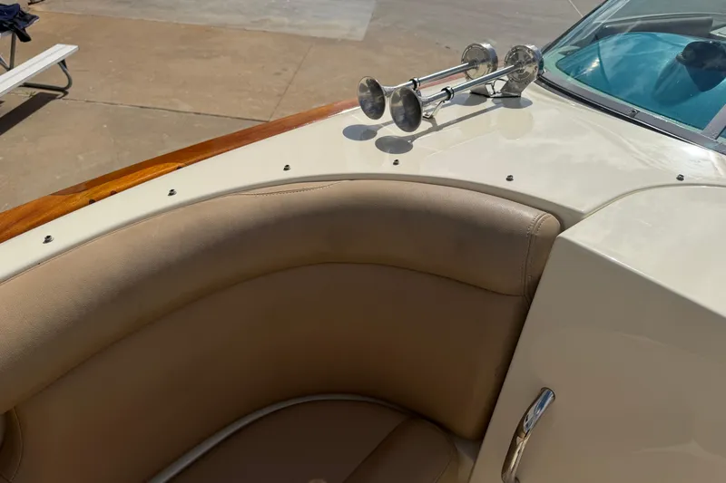 Slide: The Image of 2001 Chris-Craft Launch 28 boat interior with beige seating and chrome horns. - 24