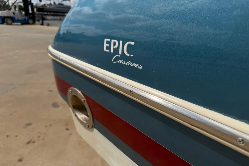 Slide: The Image of 2001 Chris-Craft Launch 28 boat with "Epic Customs" branding on blue hull. - 9