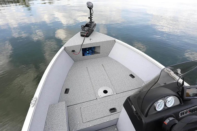 Slide: The Image of Manufacturer Provided Image: 2025 Lund 1600 Fury SS boat interior on calm water, featuring modern dashboard and storage. - 6