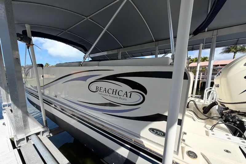 The Image of 2017 Beachcat 230 saltwater pontoon boat docked under a canopy. - 1