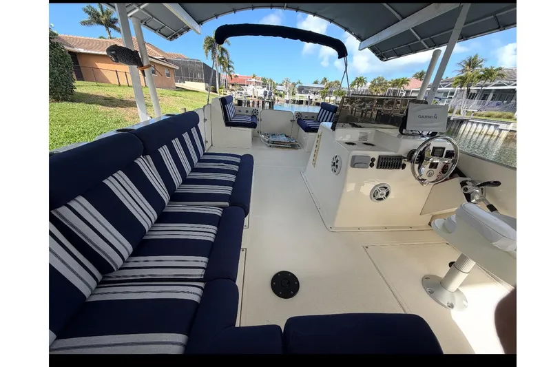 Slide: The Image of Interior of a 2017 Beachcat 230 boat with striped seating and steering console. - 12