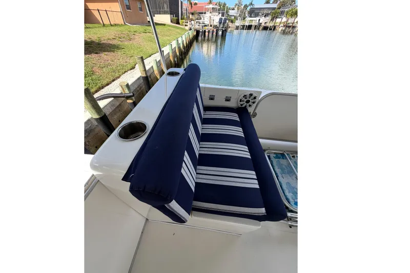 Slide: The Image of Blue and white striped seating on a 2017 Beachcat 230 boat by a canal. - 15