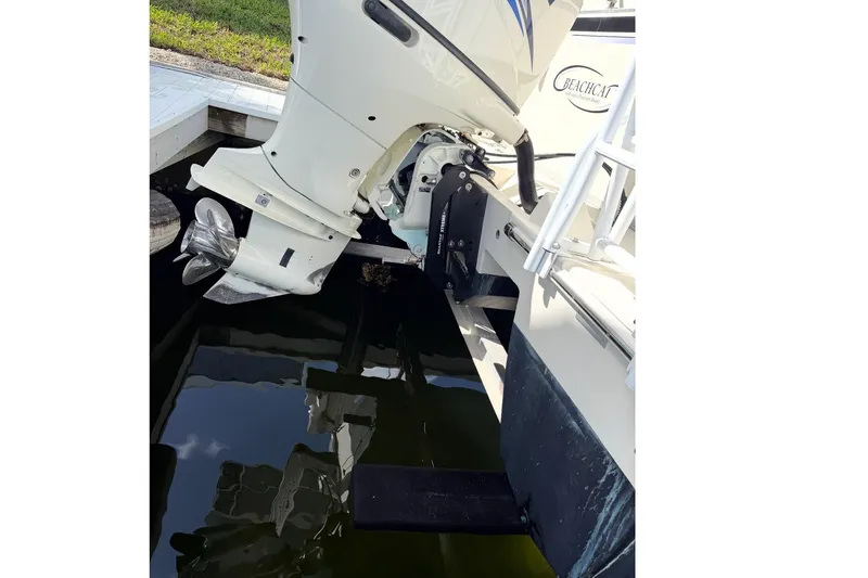 Slide: The Image of Outboard motor of a 2017 Beachcat 230 boat docked by the water. - 16