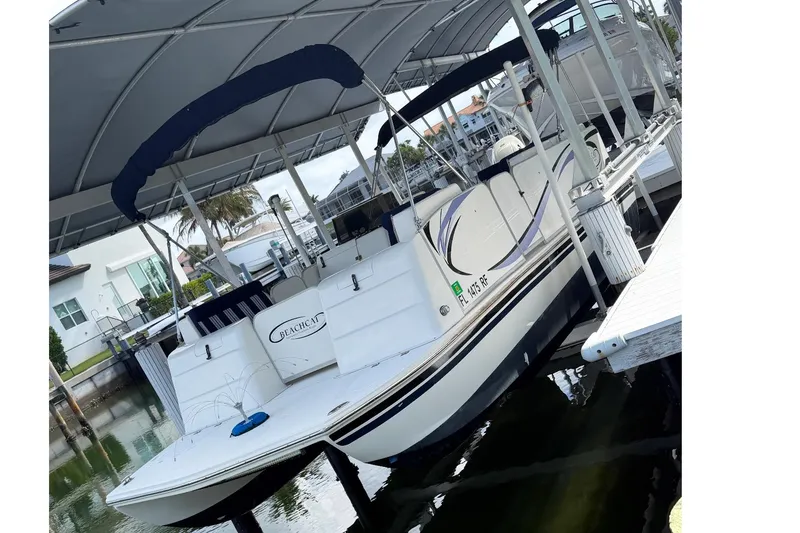 Slide: The Image of 2017 Beachcat 230 boat docked under a canopy in a marina. - 18
