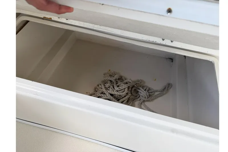 Slide: The Image of Open storage compartment with rope inside on a 2017 Beachcat 230 boat. - 7