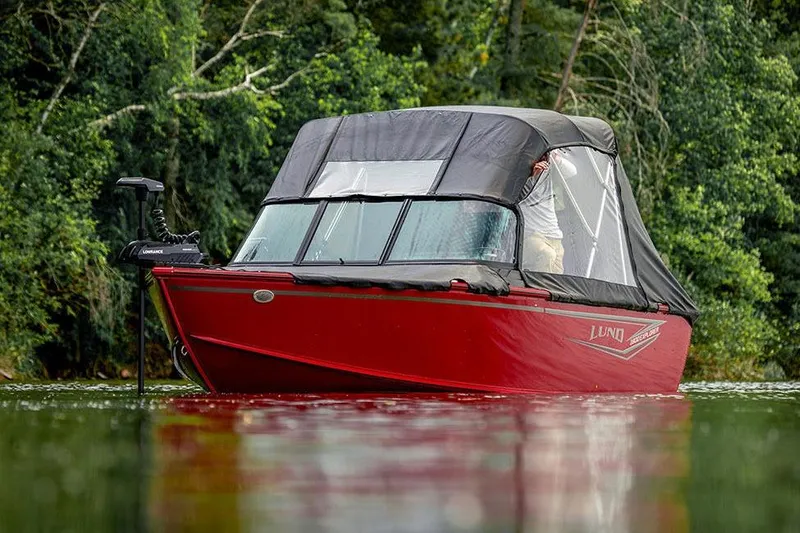 Slide: The Image of Manufacturer Provided Image: 2026 Lund 1800 Explorer Sport boat on water, surrounded by lush greenery. - 4