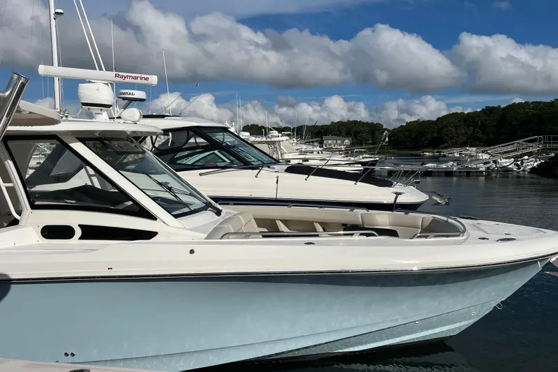 The Image of 2022 Boston Whaler 350 Realm docked at marina, showcasing spacious deck and seating. - 0