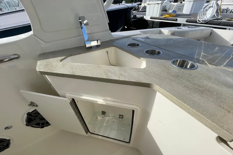 Slide: The Image of 2022 Boston Whaler 350 Realm boat interior with sink and storage compartments. - 10